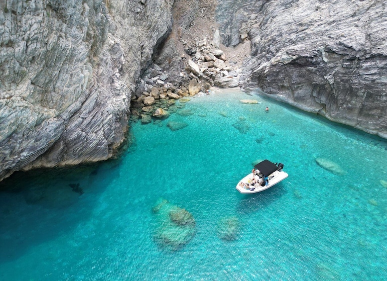 A boat in a turquoise bay surrounded by rocky cliffs. 5