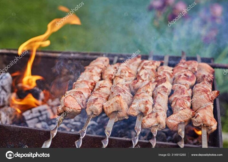 Skewered meat grilling over an open flame. 2