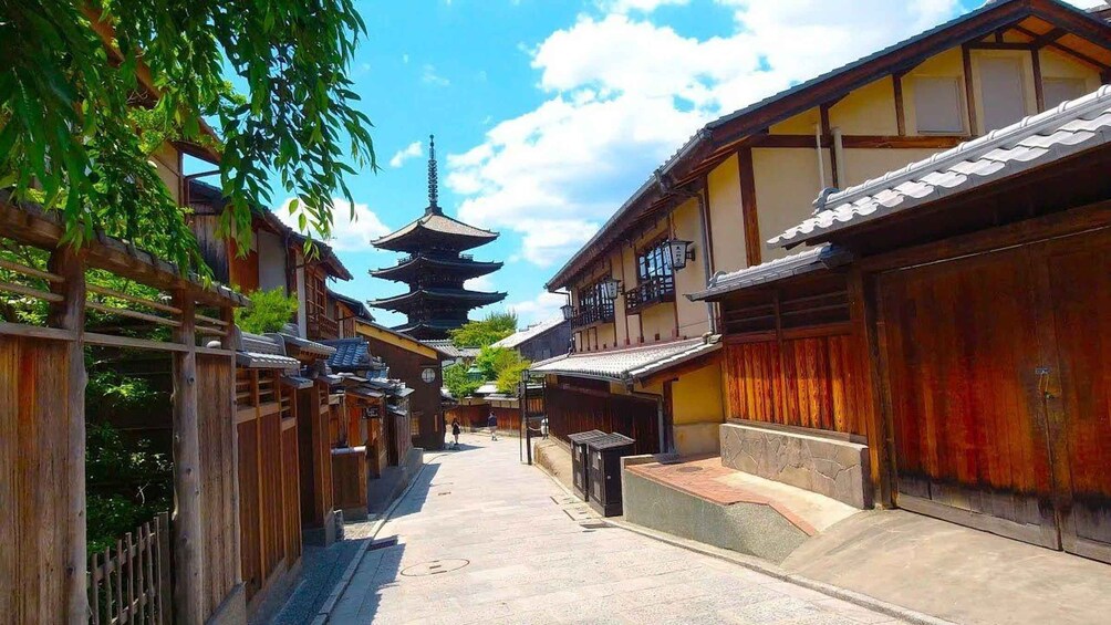 Una tipica strada giapponese con edifici in legno, una pagoda e un cielo azzurro intenso. 1