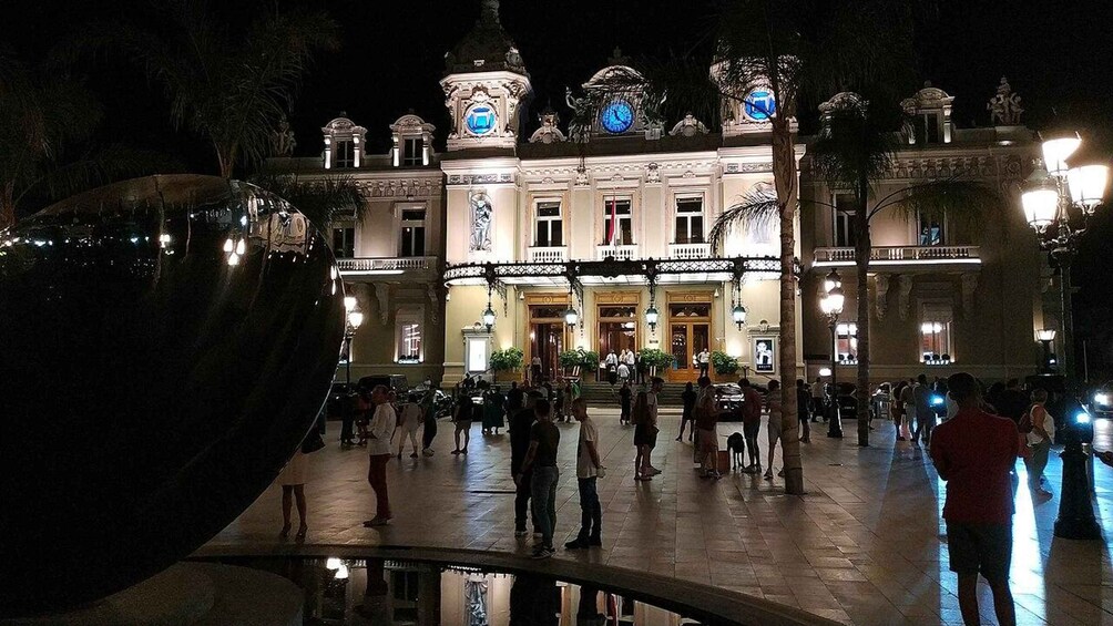 A historic building with ornate architecture and a reflective water feature in front. 4
