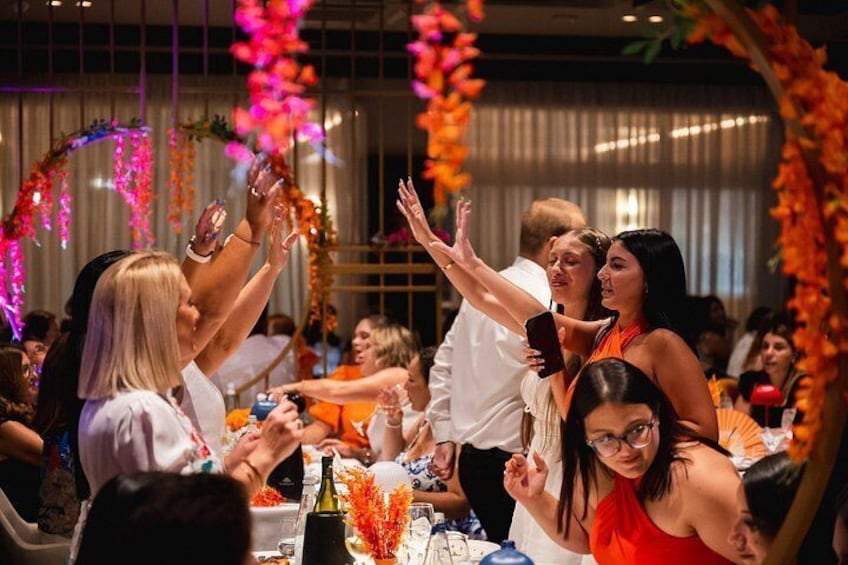 A group of people at a social event, clapping and interacting. 3