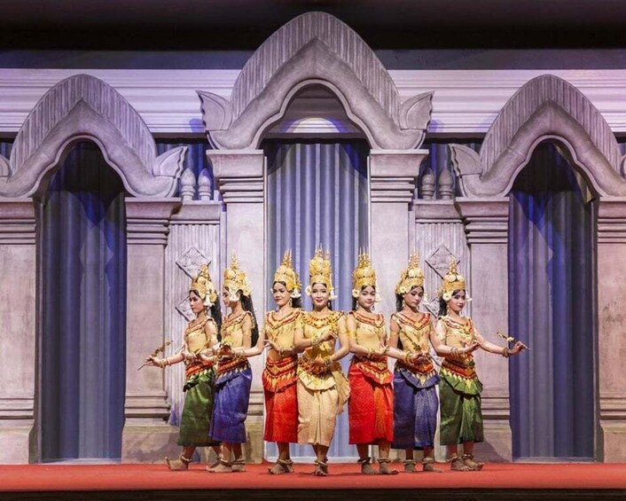 A group of dancers in traditional costumes performing on a stage with classical architecture. 2