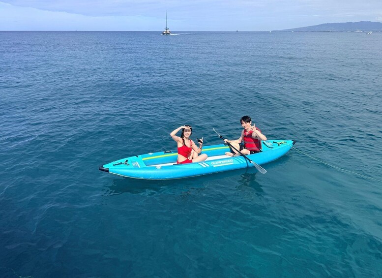 Two people in a blue kayak on calm sea water. 4