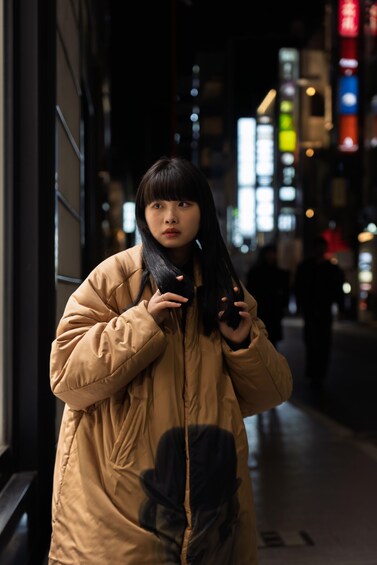 A person standing on a city street at night. 5