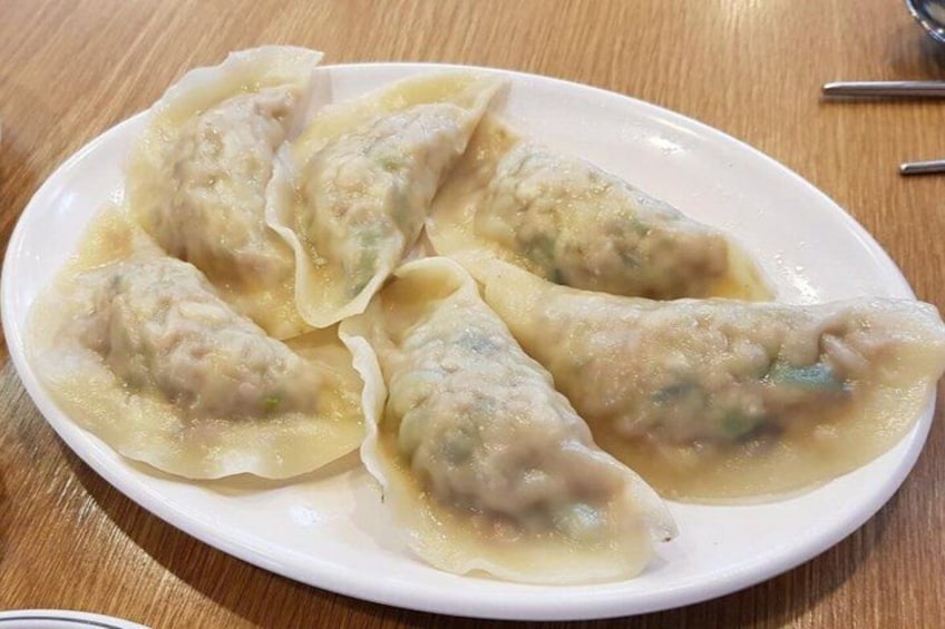 A plate of dumplings on a wooden table. 4