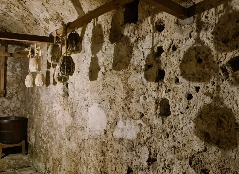 A stone interior with hanging pottery and a wooden beam structure. 2