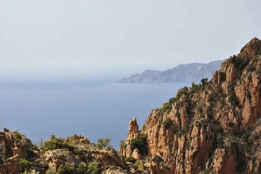 A coastal landscape with rocky cliffs and a view of the sea. 5