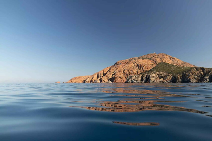 A rocky island with calm water in the foreground. 3