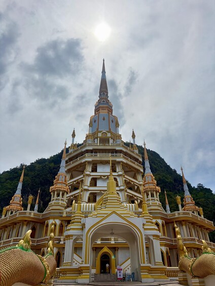 A multi-tiered temple with golden spires and a central spire, surrounded by lush greenery. 2