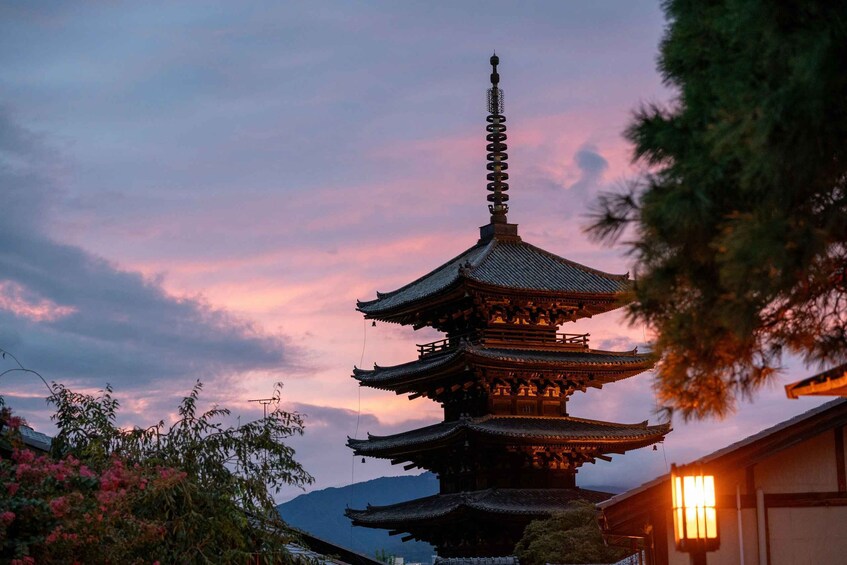 A traditional multi-tiered pagoda at dusk with a pink sky. 4