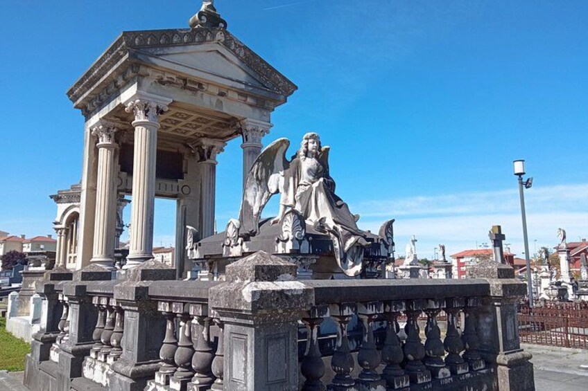 A classical monument with an angel statue, columns, and intricate carvings. 2