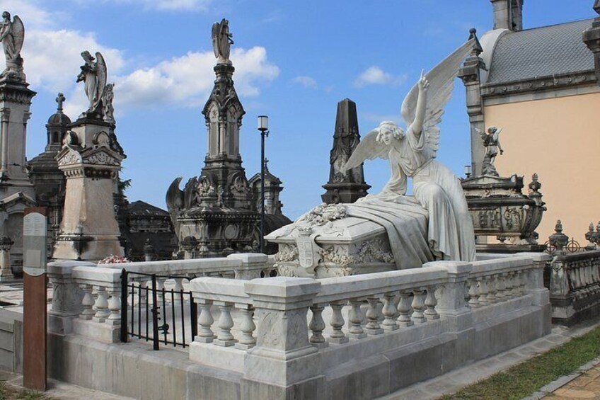A cemetery with ornate statues and a fountain. 1