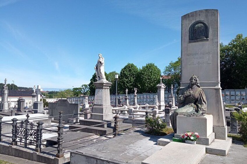 A cemetery with gravestones, statues, and a monument. 4