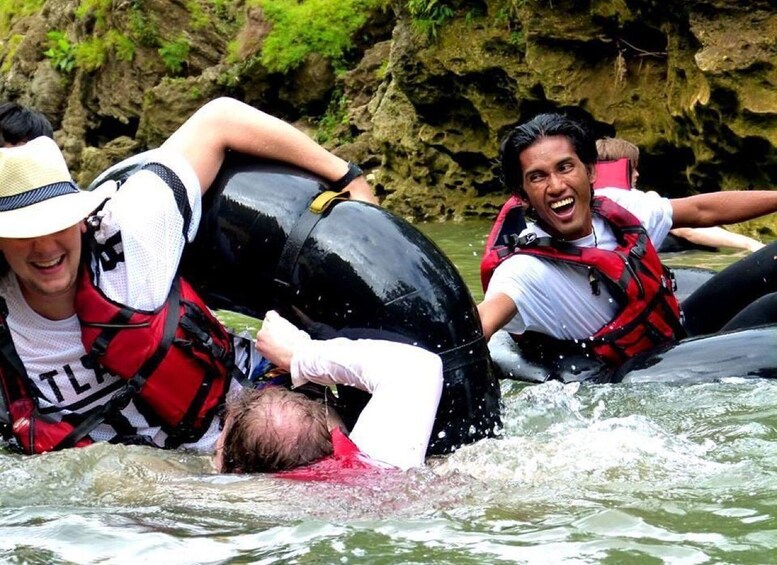 People in a white boat, wearing life jackets, navigating a river with rocky banks. 3
