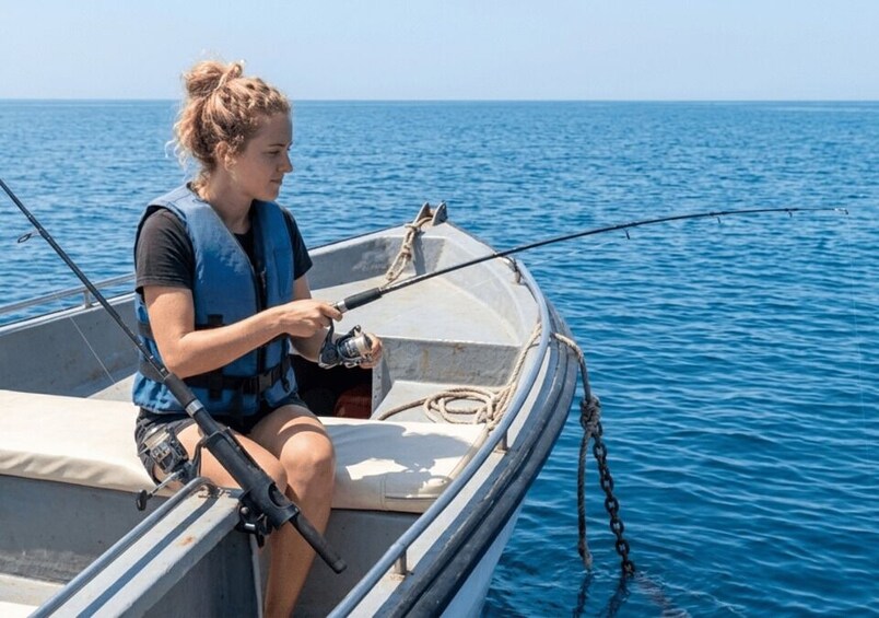 A person fishing from a small boat on a calm sea. 5