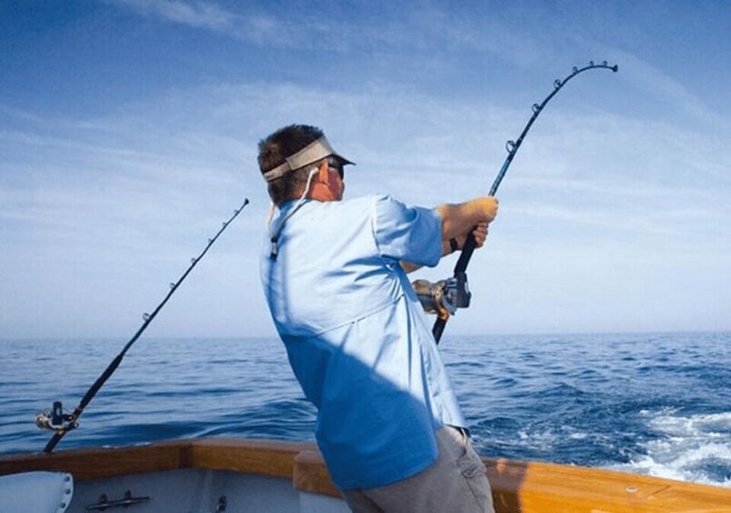 A person fishing on a boat in the ocean. 3