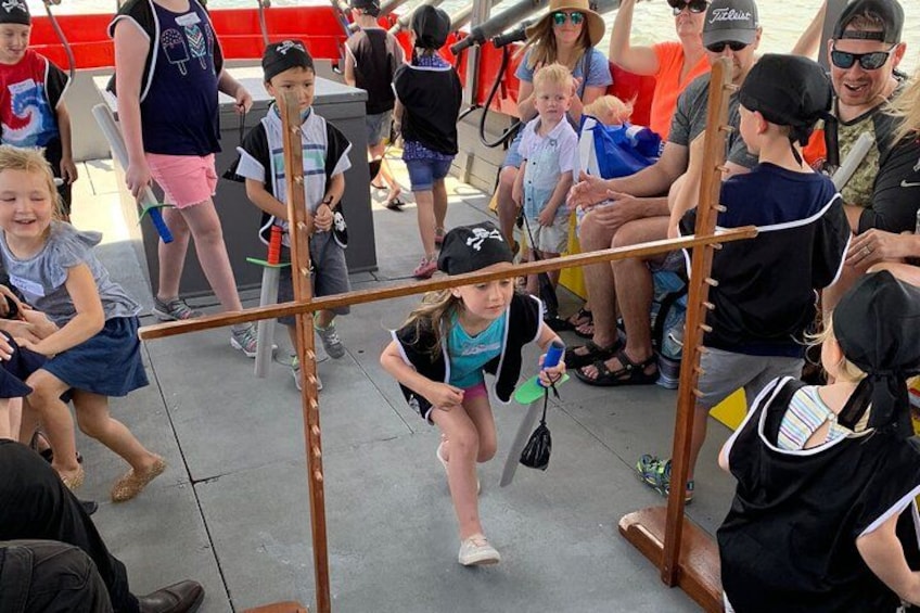 A group of children playing on a wooden obstacle course with adults watching. 4