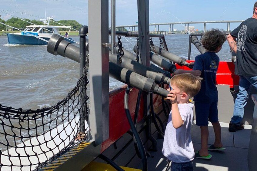 A boat with cannons, a person in a black shirt, and a child in a white shirt. 2