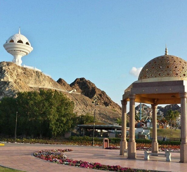 A gazebo with a dome, a white tower, and a mountainous backdrop. 5