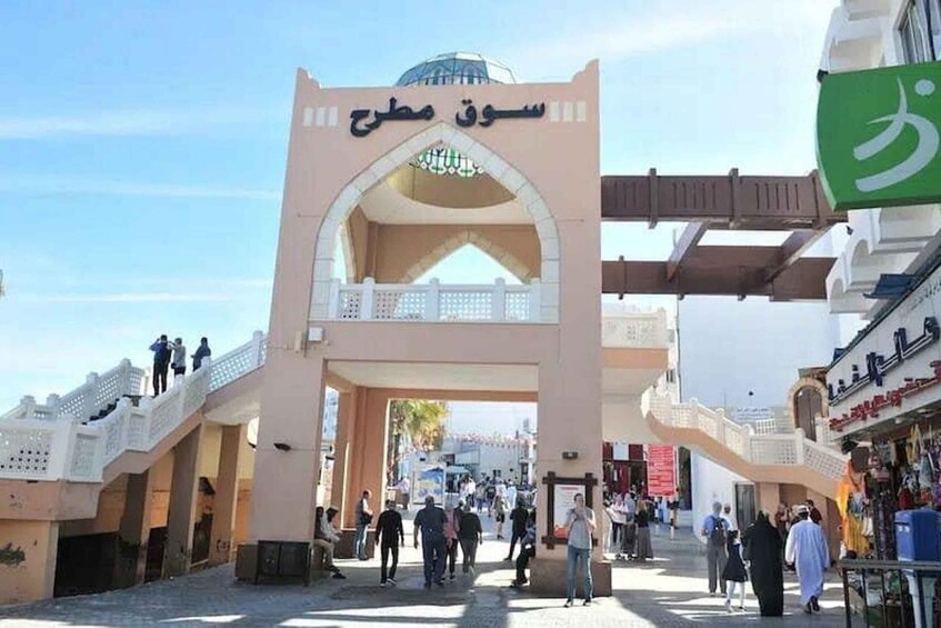 A bustling market entrance with a prominent archway and a dome structure above. 2