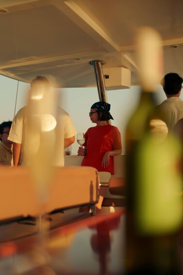 A group of people on a boat with a person holding a glass. 2