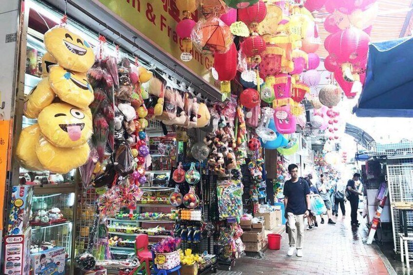 A market with various stalls selling toys and decorations, including plush toys and hanging lanterns. 1
