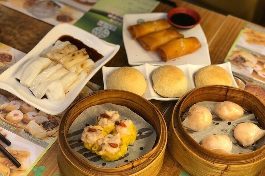 A variety of Asian dishes including dumplings, buns, and a plate of spring rolls. 2
