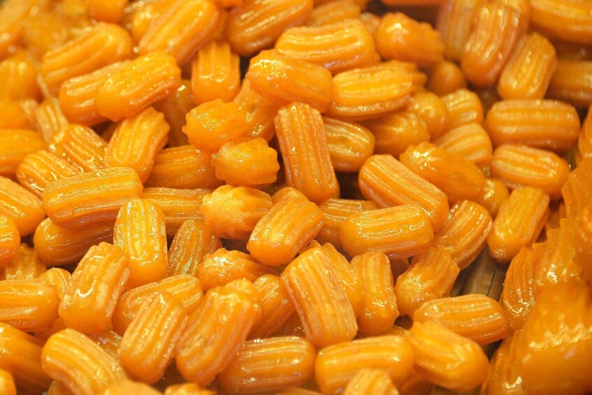 A close-up of shiny, orange-colored, ridged food items. 2