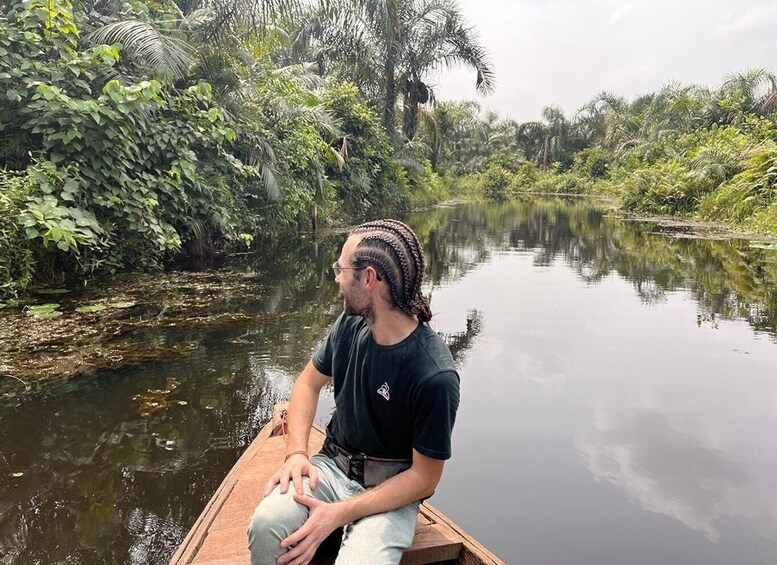A person in a boat on a calm river surrounded by dense tropical vegetation. 5