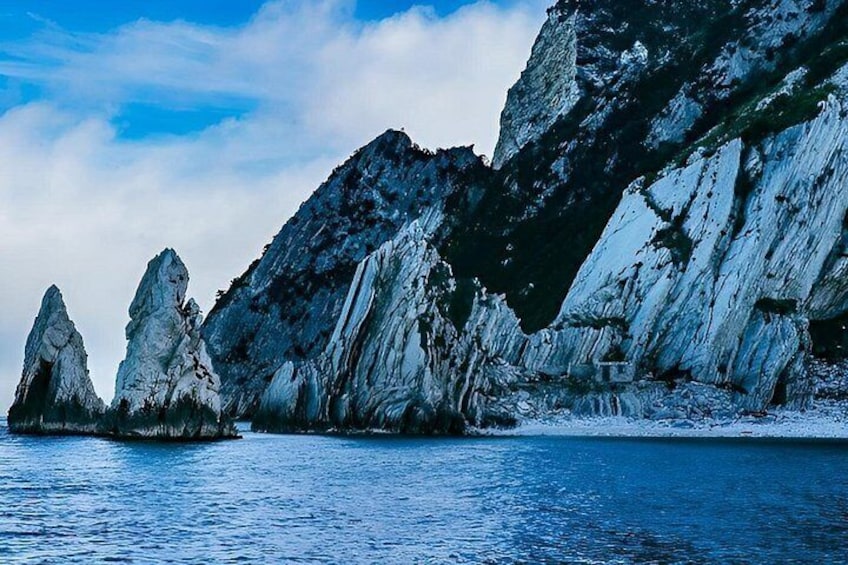 A coastal landscape with towering rock formations and a calm sea. 2