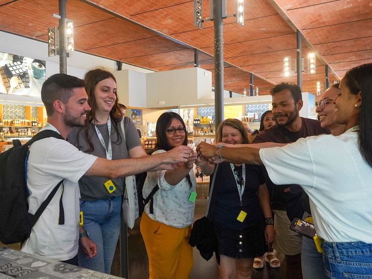 Un groupe de personnes se trouve dans un magasin dont le plafond est en briques et où les étagères sont remplies de produits. 5