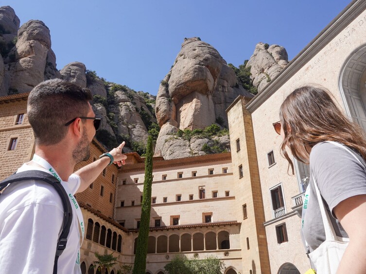 Un bâtiment historique doté d’une cour intérieure, de grandes formations rocheuses et surplombé d’un ciel bleu azur. 4
