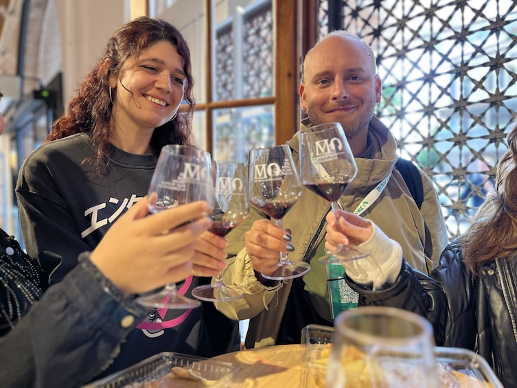 Deux personnes trinquent avec des verres de vin autour d’une table sur laquelle se trouve un code QR. 2