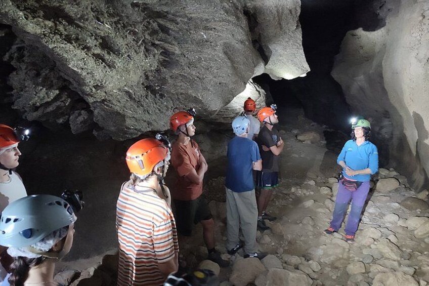 A group of people wearing helmets and headlamps inside a cave. 4