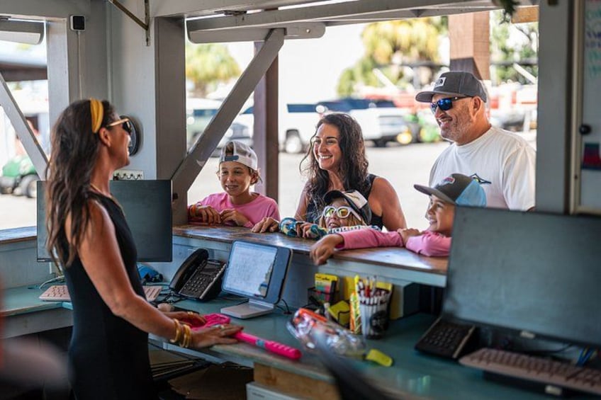Un furgone gastronomico con un bancone, una persona che serve e una famiglia di quattro persone. 2