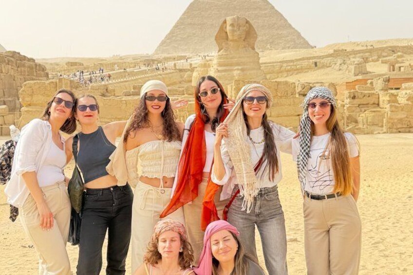 A group of people standing in front of the Great Pyramid of Giza. 3
