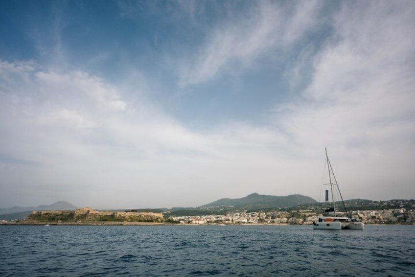 A sailboat on calm waters with a mountainous coastline and a clear sky in the background. 4