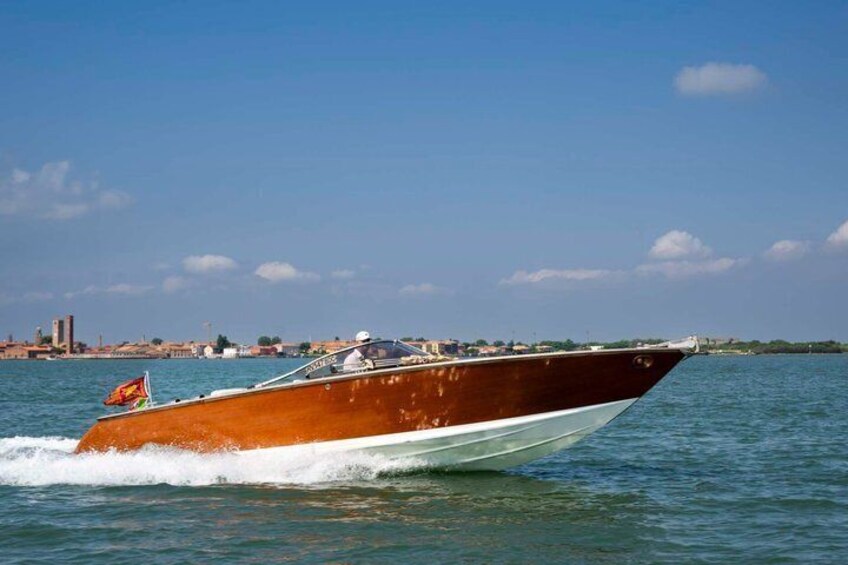 A speedboat on water with a cityscape in the background. 4