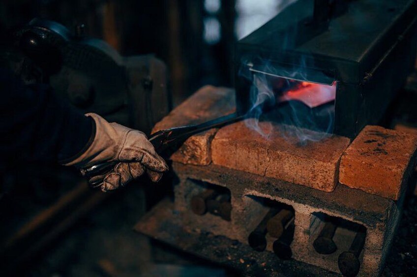 A person using a tool on a brick structure with a glowing red element. 4