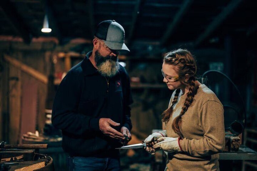 Two people in an industrial setting, one holding a clipboard. 2