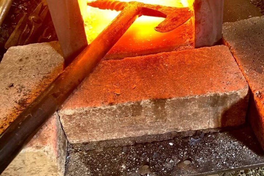 A metalworking process with a glowing hot metal piece and a hammer. 5