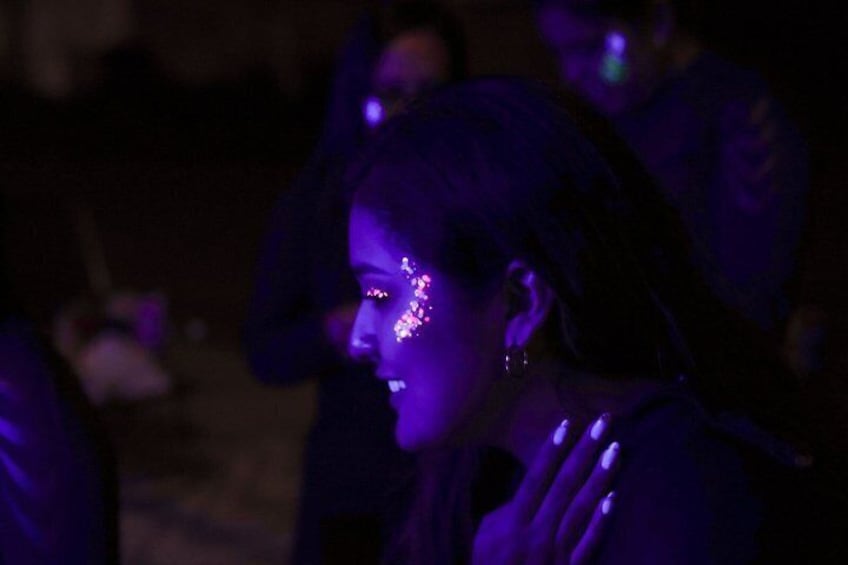 A person with purple lighting effects on their face. 5