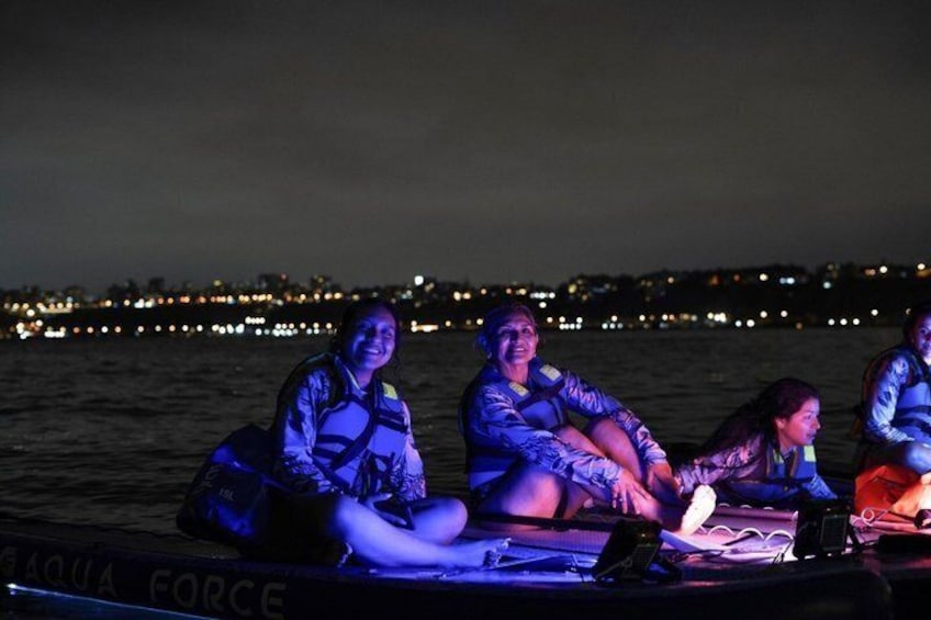 A boat with people wearing life jackets, a city skyline in the background, and the text 'AQUA FORCE' on the side. 1