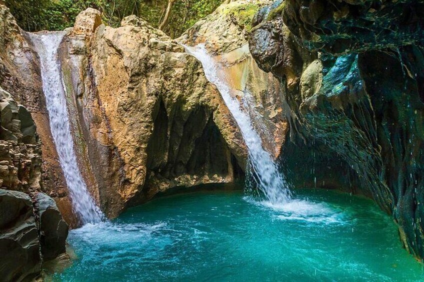 A multi-tiered waterfall with clear turquoise water flowing into a pool. 5