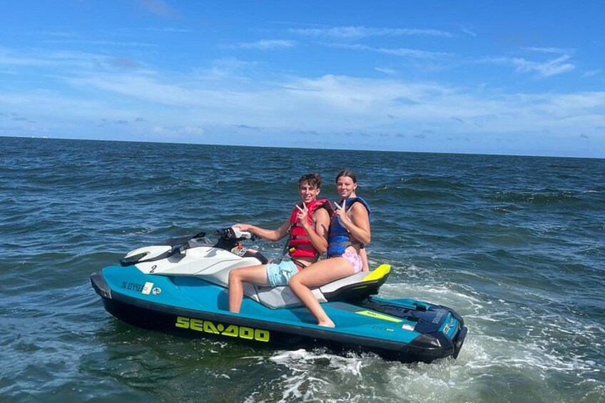 Dos personas en un jet ski Sea-Doo sobre aguas abiertas. 3