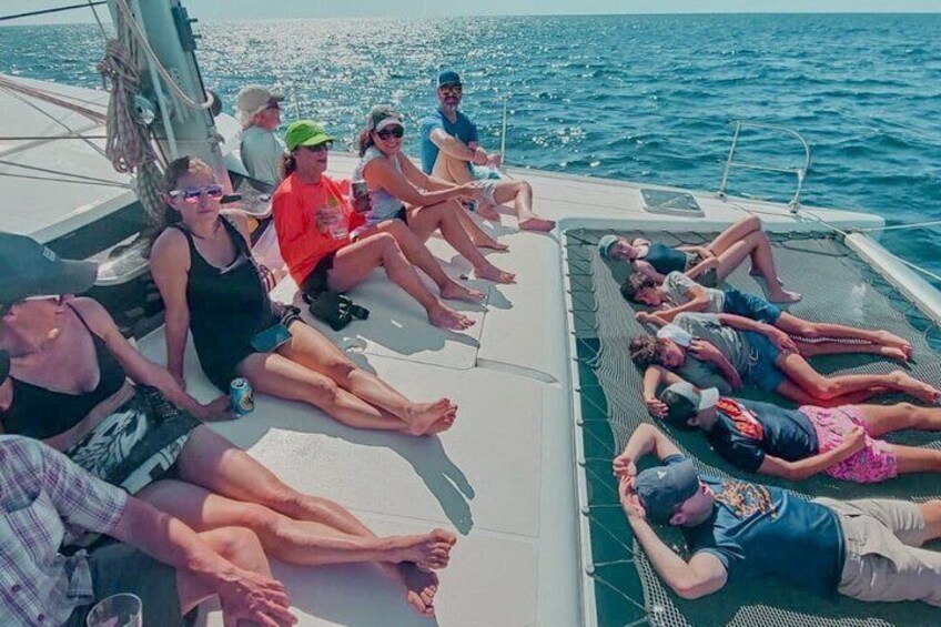 A group of people relaxing on a boat deck with the ocean in the background. 2