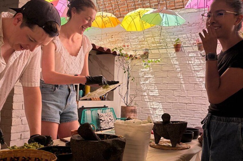 People working with plants, possibly gardening, in a rustic setting with brick walls and umbrellas. 2
