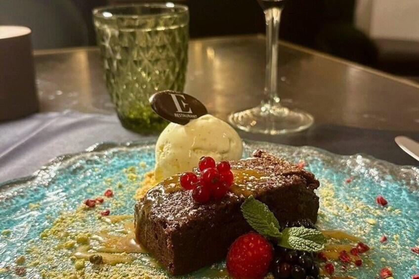 A dessert plate with a chocolate cake, berries, and a scoop of ice cream. 4
