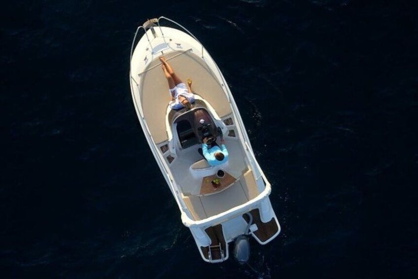 A small boat with a person on board, a motor at the stern, and a wake behind it. 3