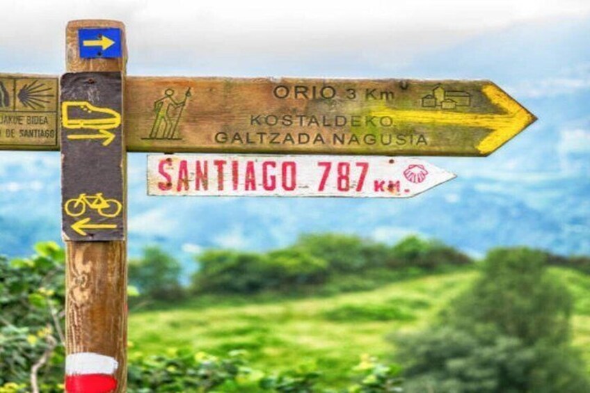 A wooden signpost with directional arrows and distance markers. 4